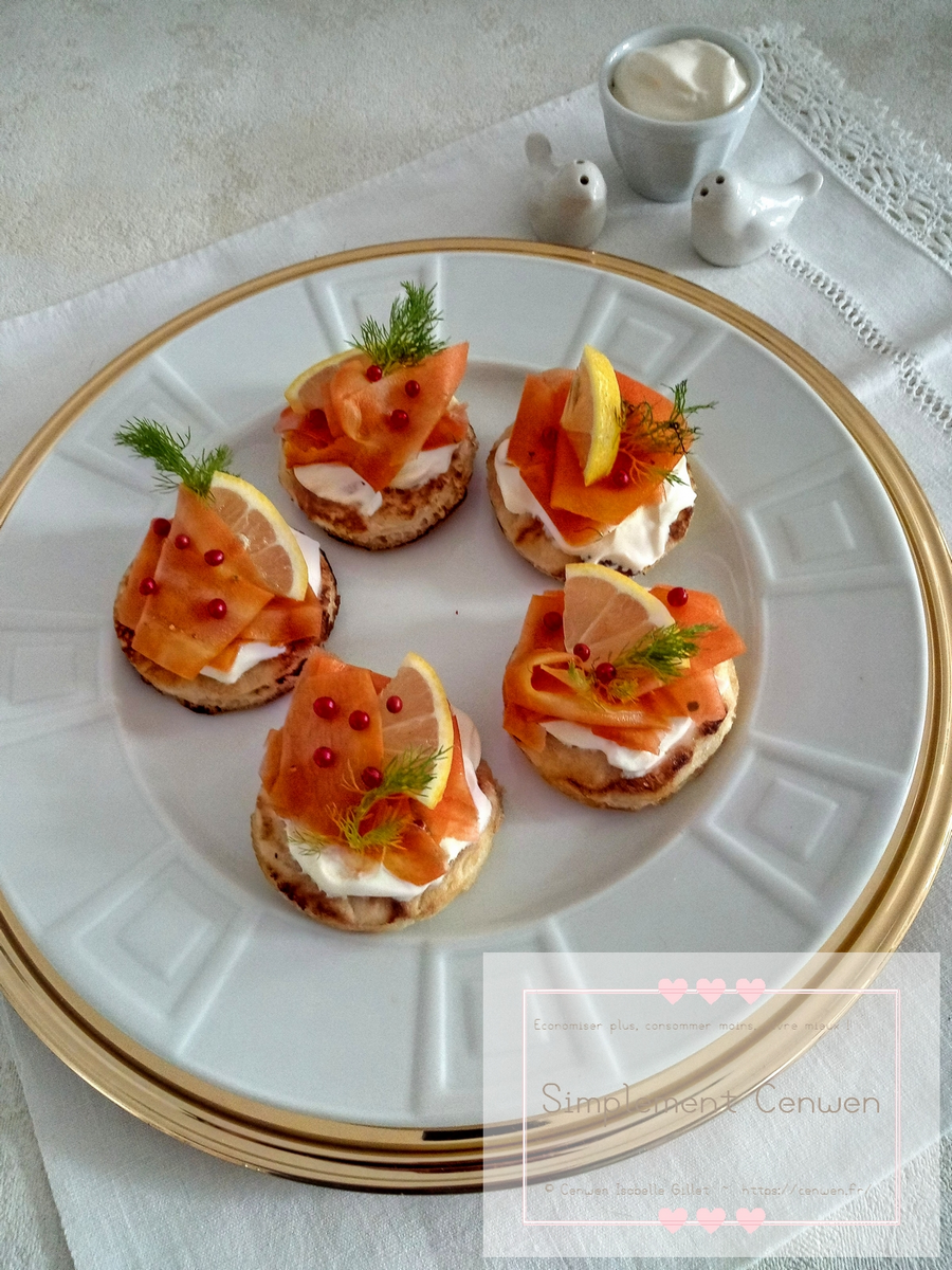 Blinis garnis de gravlax de carottes marinées, servis en bouchées festives.