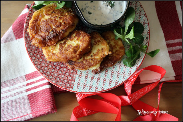 Croquettes de purée, sauce au yaourt et salade sur une assiette rouge et blanche