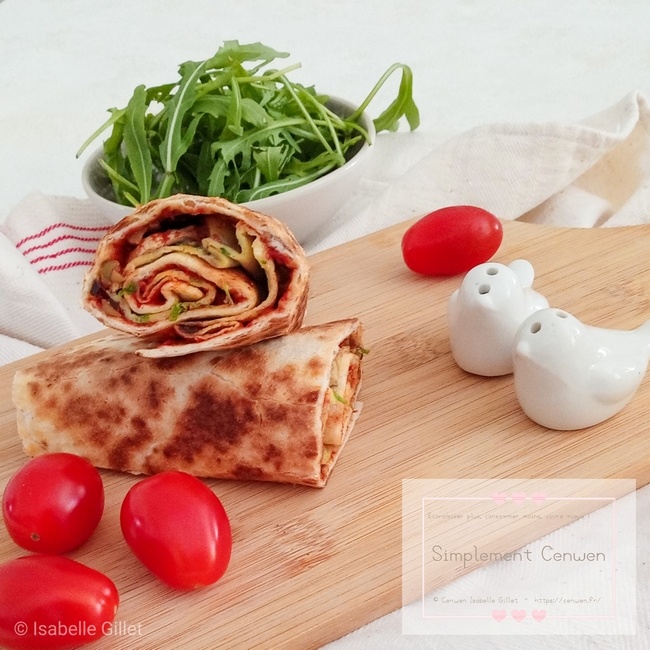 Deux moitiés de wrap garnies d’omelette, de champignons et d’olives, disposées dans une assiette avec un petit bol de salsa rouge à côté.