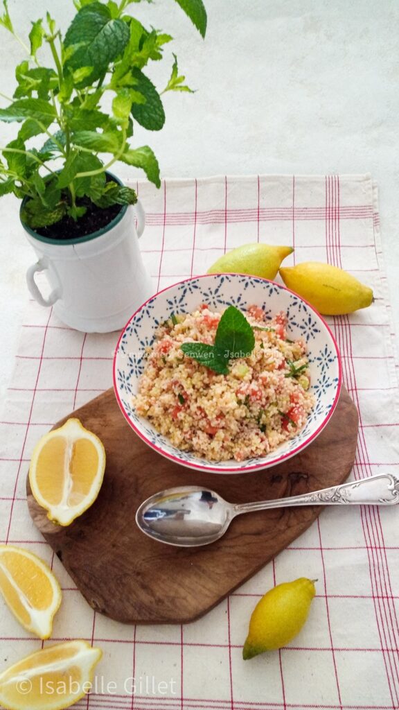Photo d'archive : Bol de taboulé à la menthe avec semoule, tomates, concombre et herbes fraîches