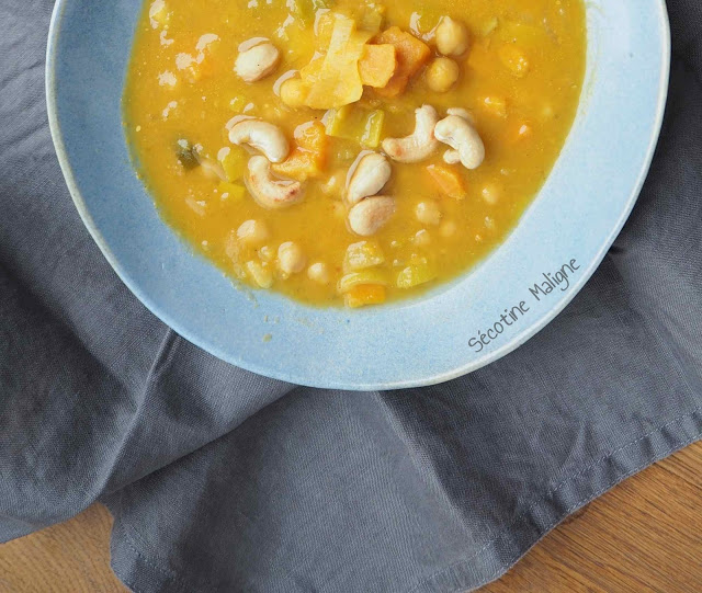 Soupe de patate douce et pois chiches aux noix de cajou dans une assiette blanche