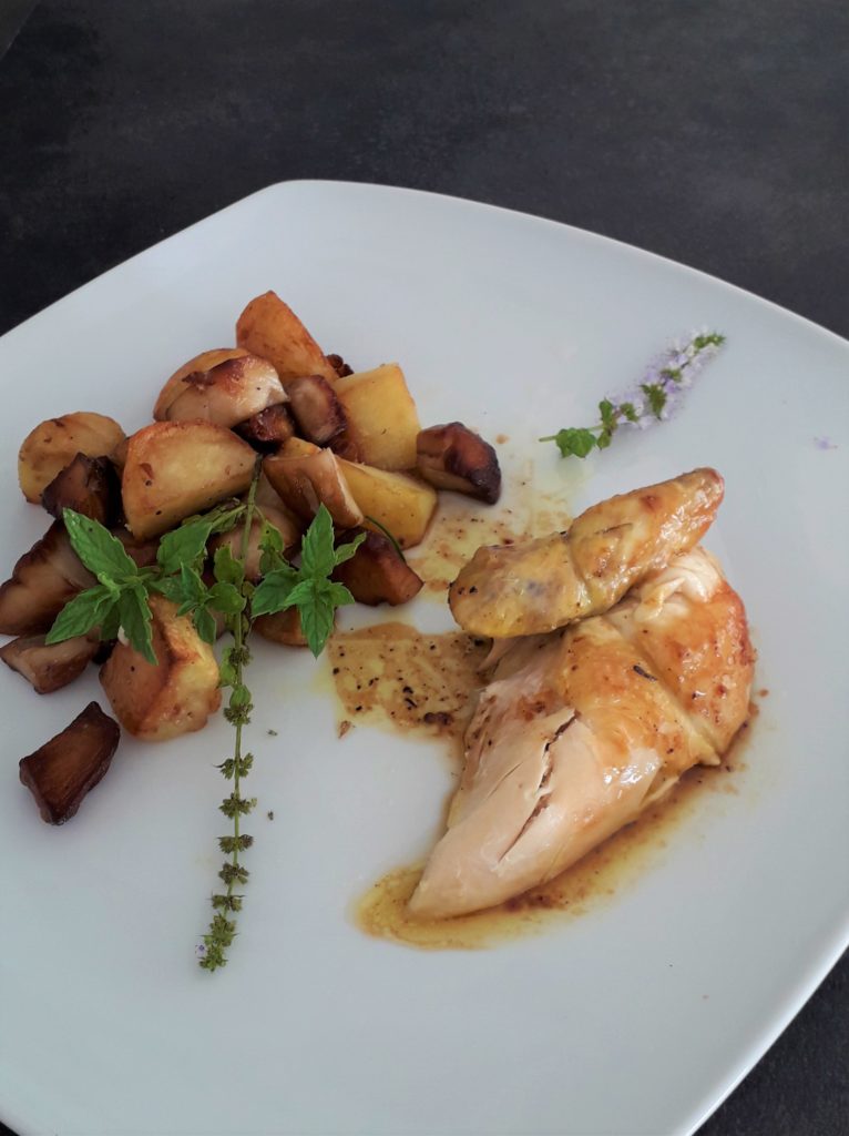 Assiette de coquelet rôti avec pommes de terre sautées et cèpes, plat économique et gourmand.