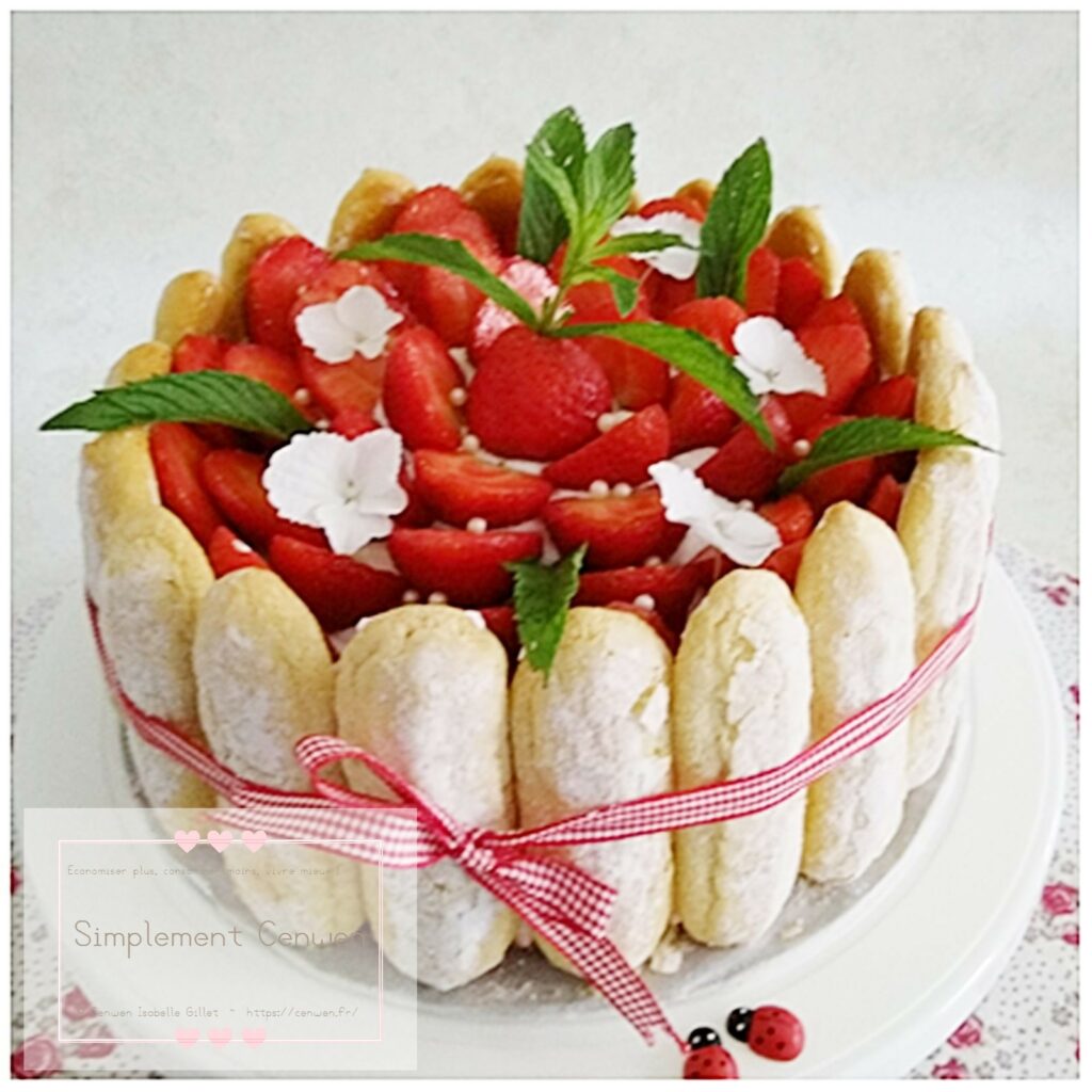 Charlotte aux fraises garnie de crème légère et de fraises fraîches, joliment démoulée.