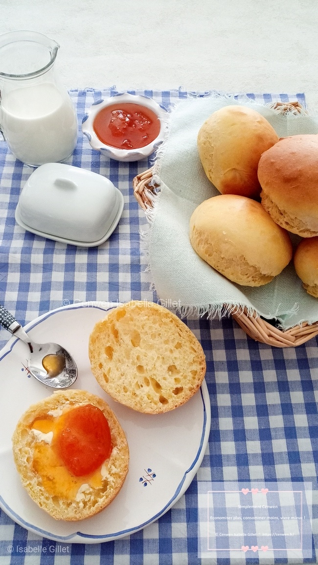 Petits pains au lait dorés et moelleux, disposés sur une assiette posée sur un torchon à carreaux.