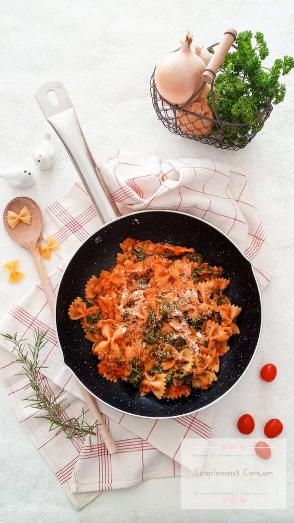 Assiette de pâtes aux épinards avec sauce crémeuse à la tomate, plat végétarien simple et économique.