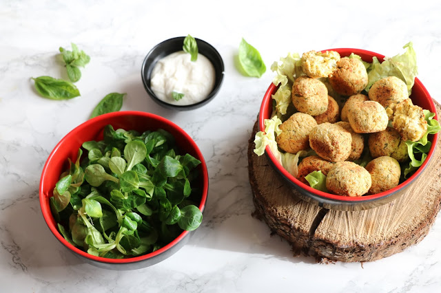 Falafels au four dans un bol rouge, salade et sauce au yaourt
