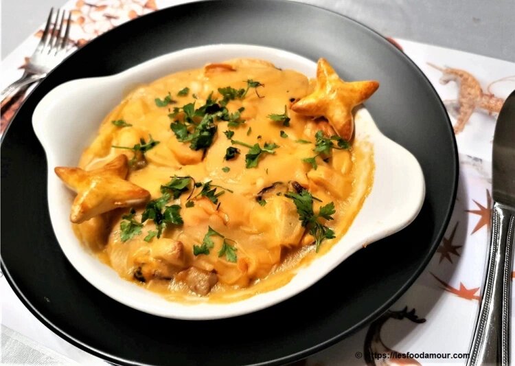 Cassolette de fruits de mer gratinée, servie chaude.