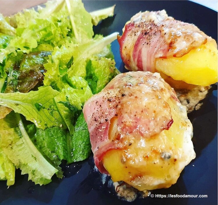 Pommes de terre au four farcies au Roquefort et entourées de lard croustillant.