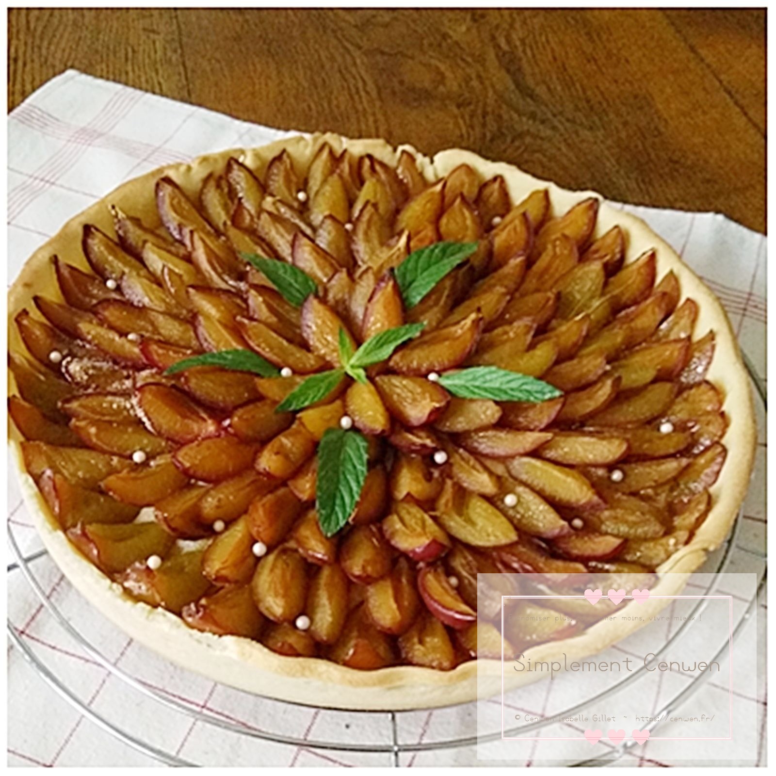 Tarte aux prunes dorée, garnie de prunes fraîches légèrement confites.