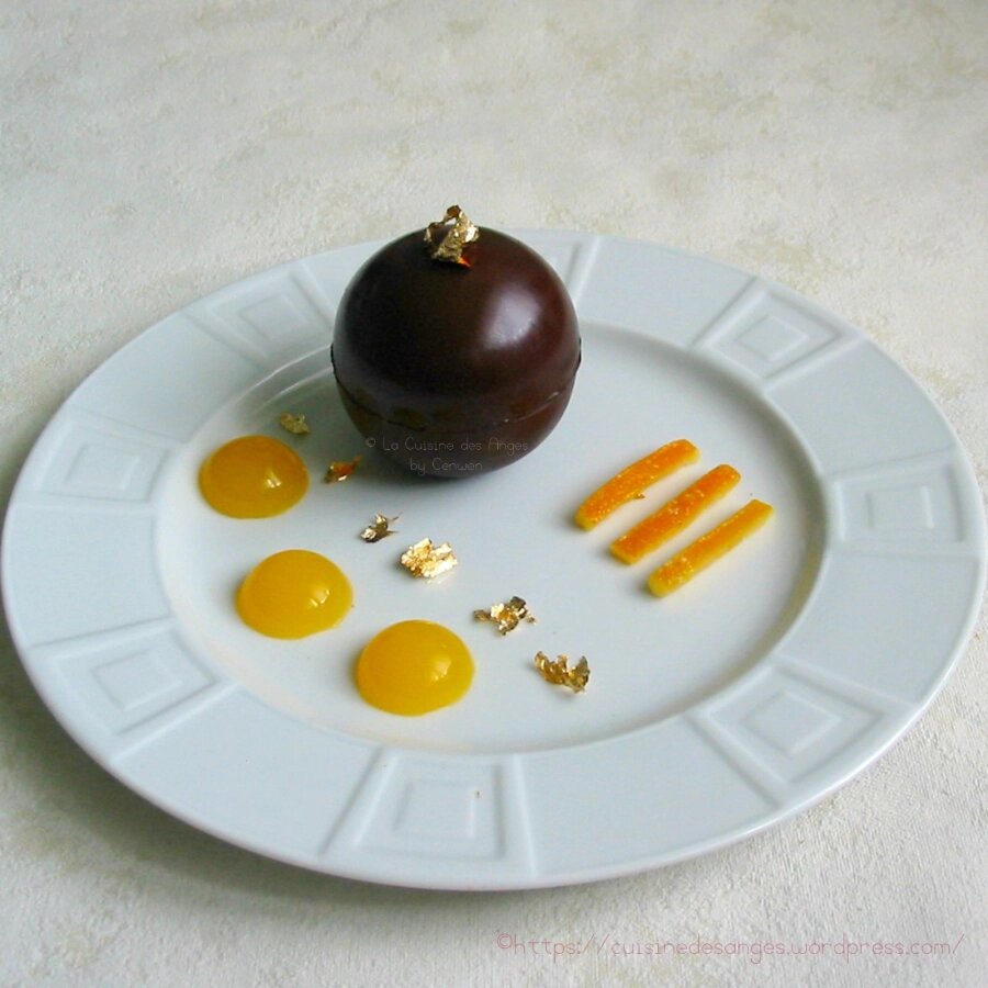 Mousse au chocolat noir servie en coque de chocolat avec oranges confites