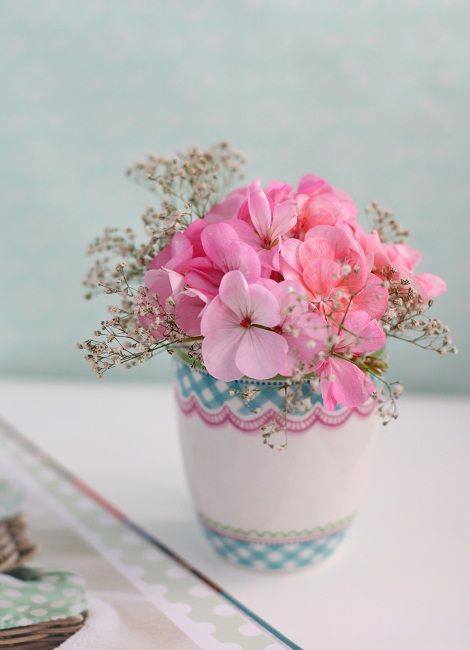 petit bouquet de fleurs roses dans un vase blanc à motifs bleus