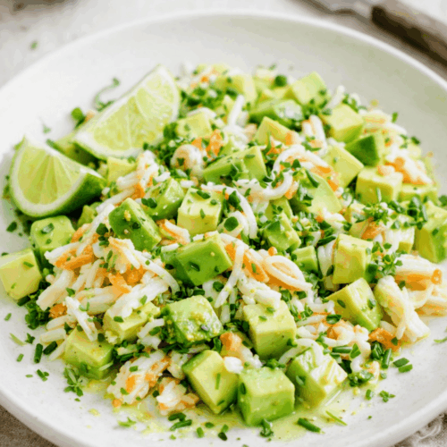 Salade fraîcheur d'avocat et surimi au citron vert et surimi dans une assiette claire.